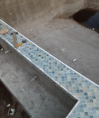 A serene pool featuring a beautifully tiled wall and a matching tiled floor