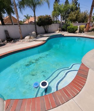 A pool scene featuring a hose and a nozzle, ready for watering or cleaning tasks.