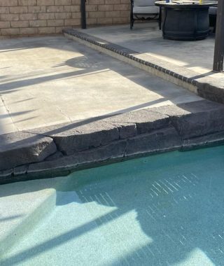 A pool surrounded by a stone wall