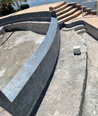 A concrete pool featuring steps that lead into the water