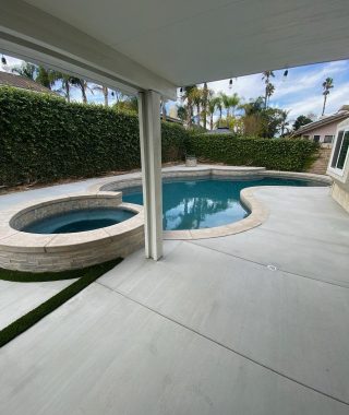 A spacious pool and patio area featuring a large, inviting patio for relaxation and outdoor gatherings.