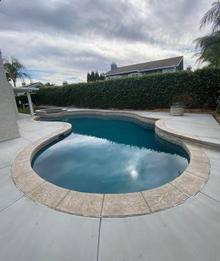 A spacious pool and patio area featuring a large, inviting patio for relaxation and outdoor gatherings.