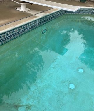 A pool featuring a blue tiled floor