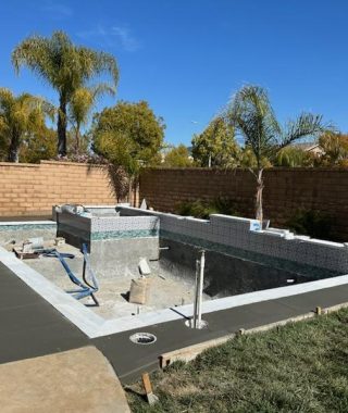 A construction site in a backyard featuring a pool under development