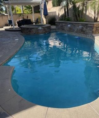 A serene poolside scene featuring a gazebo and stylish patio furniture