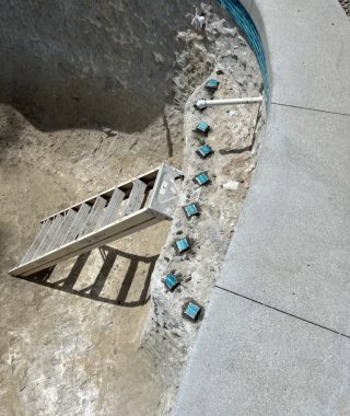 A concrete swimming pool featuring a ladder for easy access.