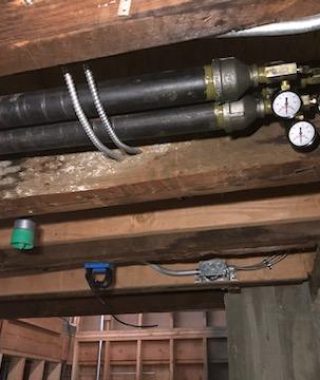 A pipe and valve installed in a dimly lit basement