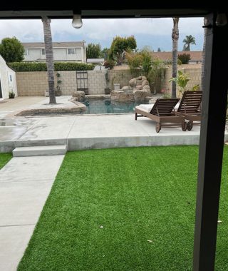 A serene backyard featuring a sparkling pool surrounded by a spacious patio area